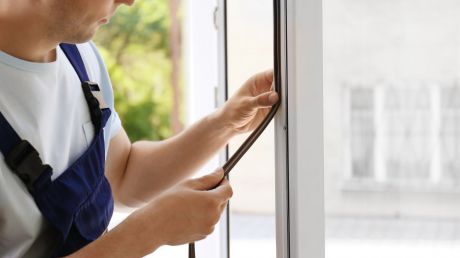 człowiek uszczelniający okno